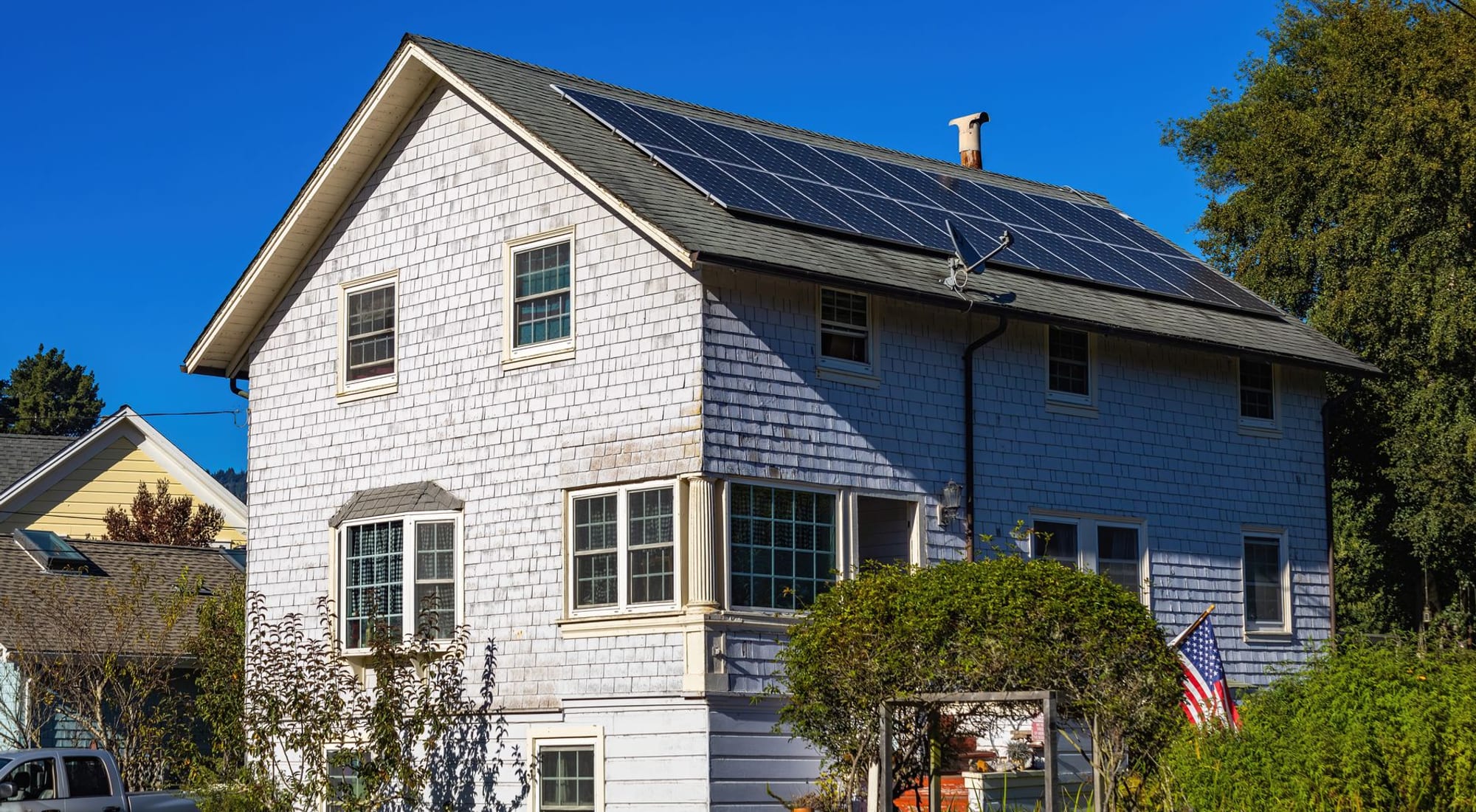 A modern home with rooftop solar panels in calm daylight